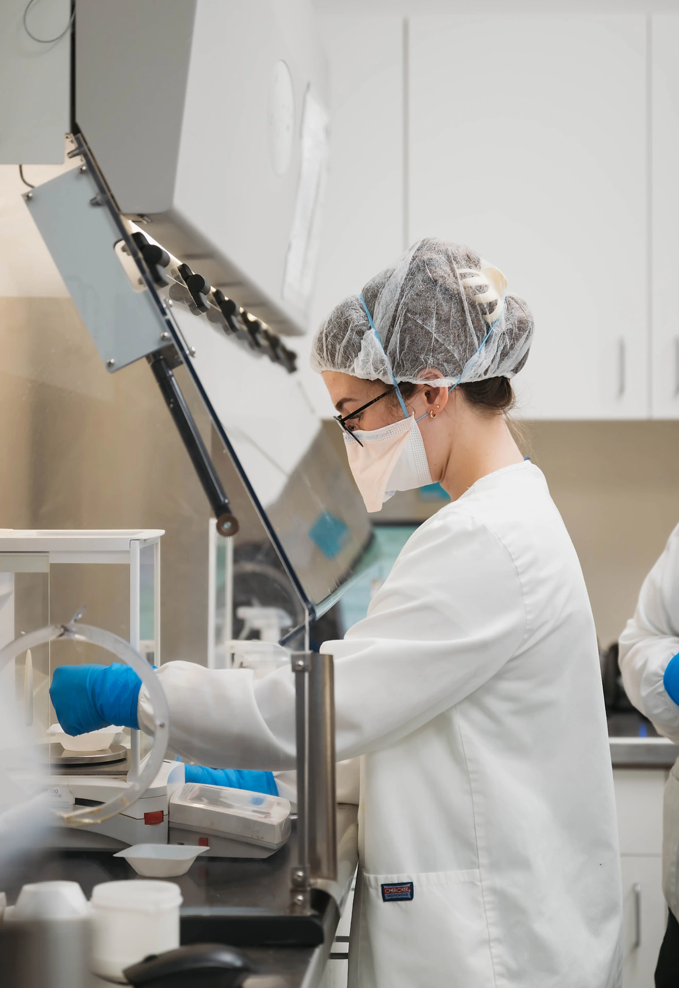 Dandurand pharmacist weighing hormone ingredients under the containment hood in Wichita, KS