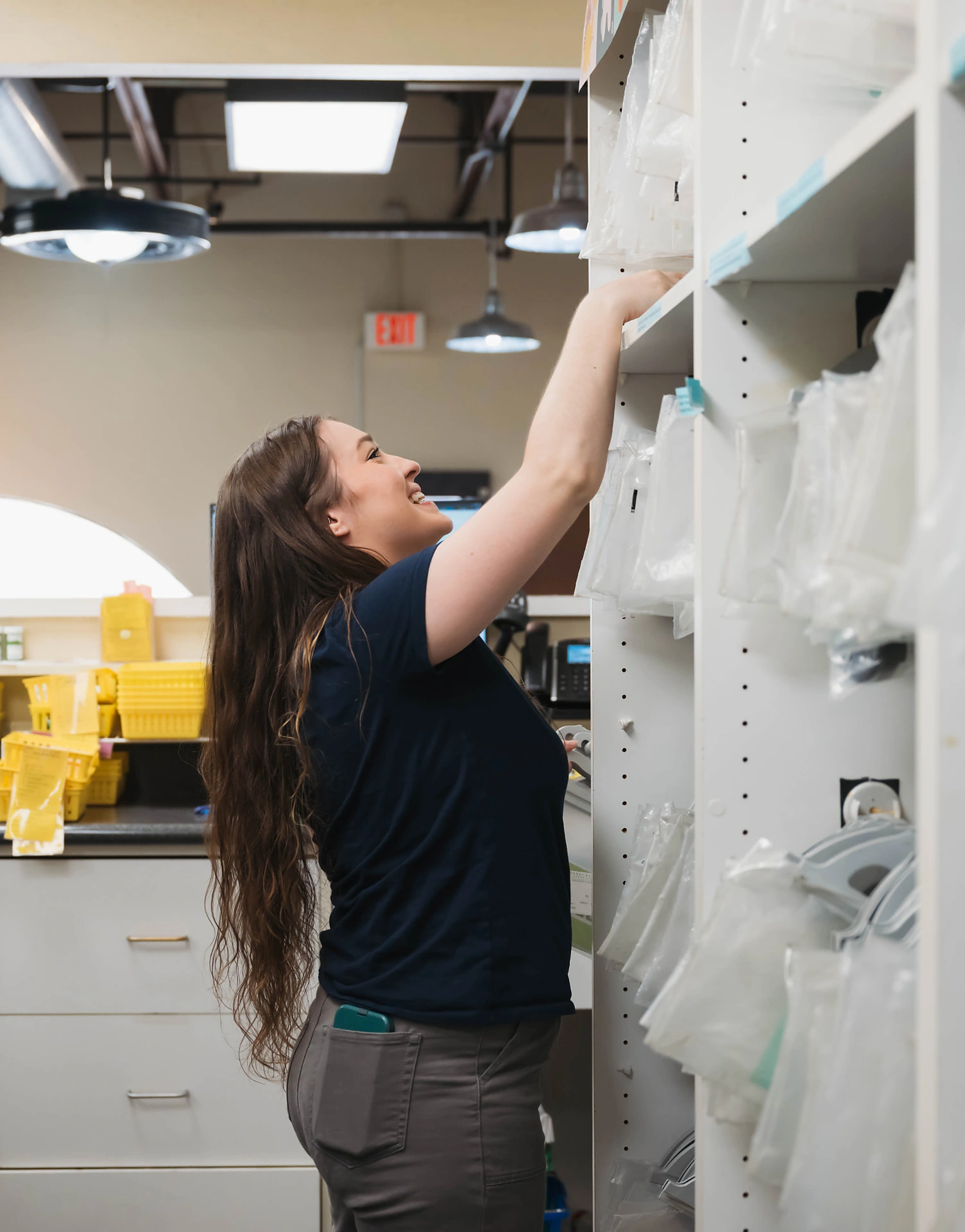 Dandurand team member reaching for pharmacy supplies